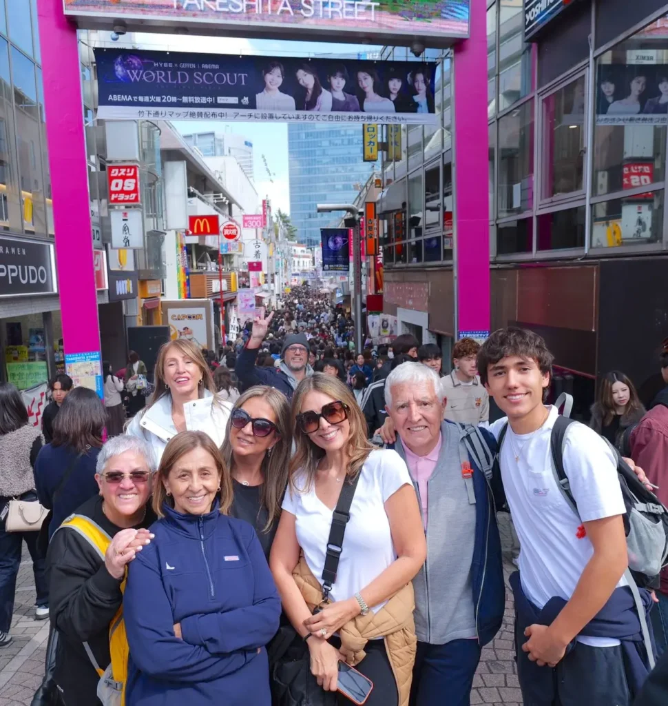 Crowded pedestrian shopping street in Tokyo, with visitors and colorful storefront signs